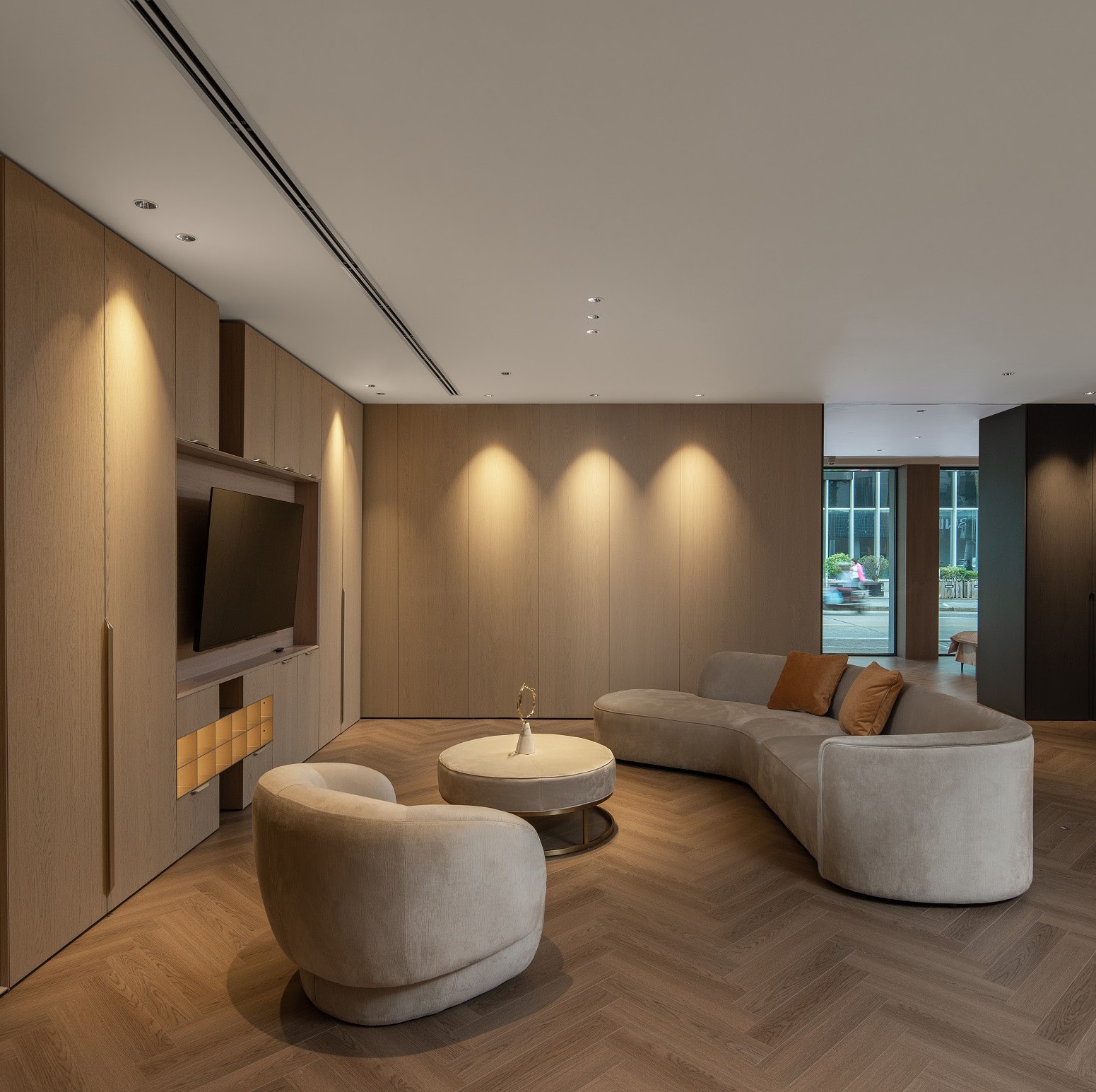 Woonkamer met houten wandkasten en zachte zitmeubels